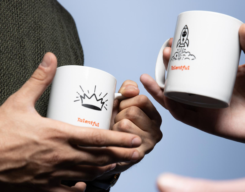 two people holding talentful mugs
